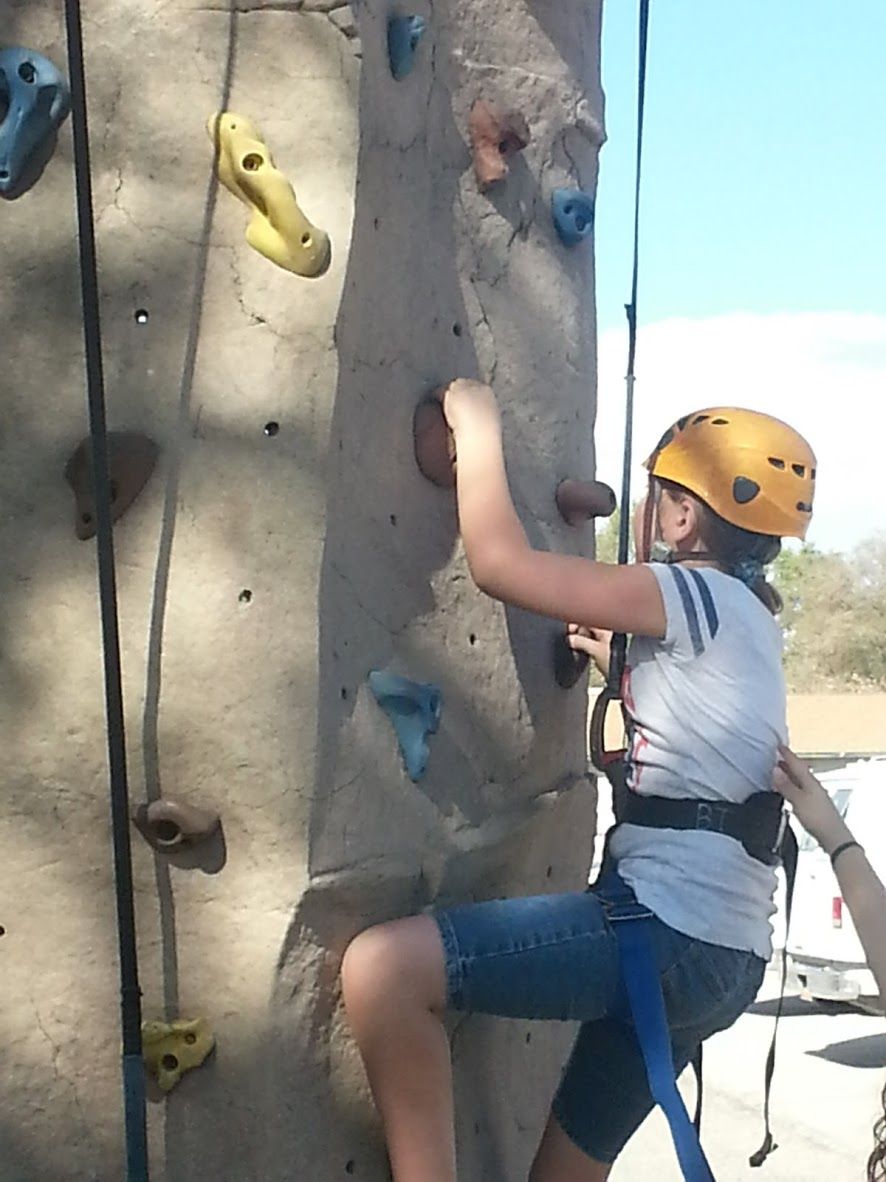 A camper climbing a rock wall
