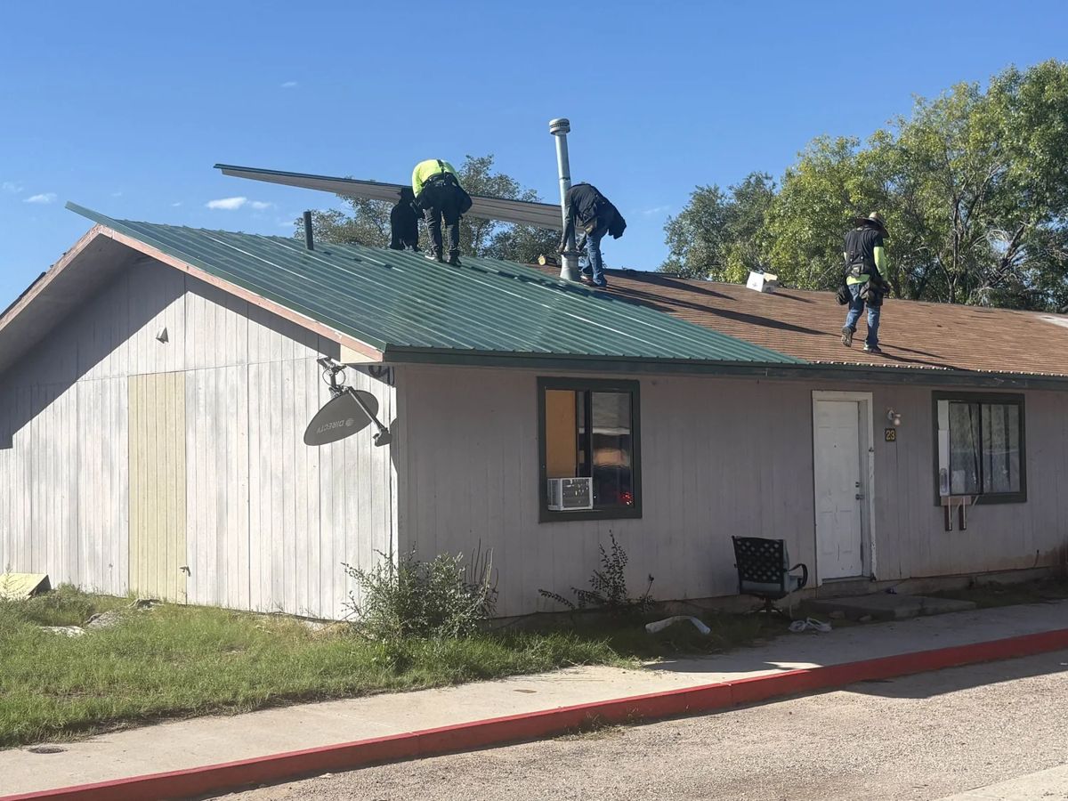 A volunteer team repairing a roof on the South Valley campus