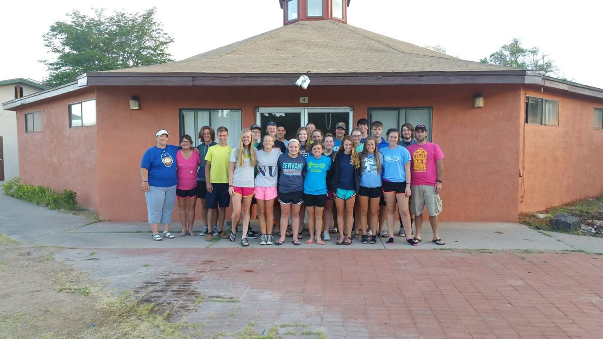A youth mission team standing in front of a Mission ABQ building